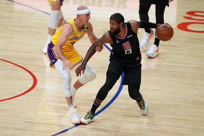 May 6, 2021; Los Angeles, California, USA; LA Clippers guard Paul George (13) handles the ball while defended by Los Angeles Lakers guard Alex Caruso (4) in the first half at Staples Center. Mandatory Credit: Kirby Lee-USA TODAY Sports